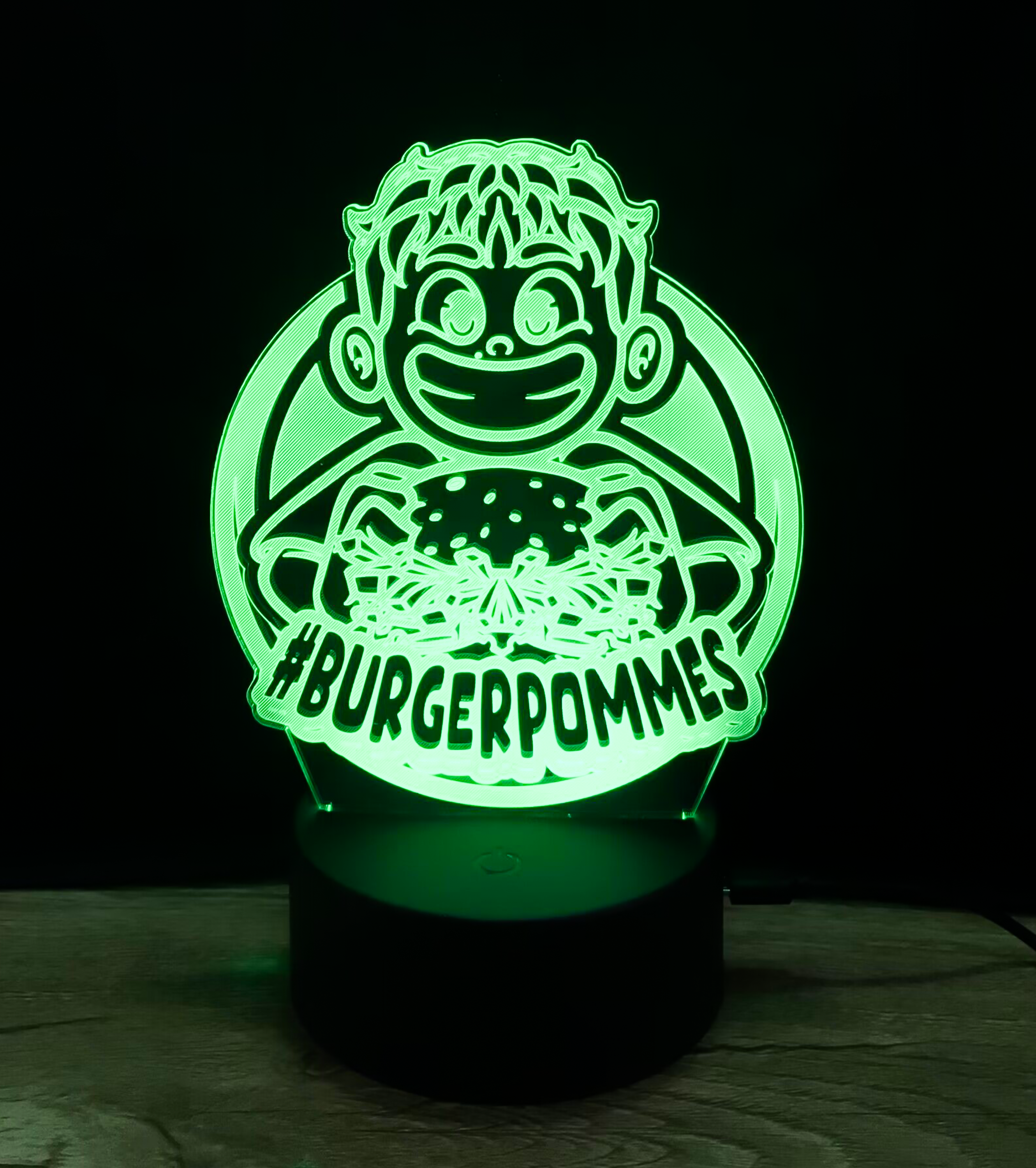 Grün leuchtende LED-Lampe im Burgerpommes-Design auf schwarzem Sockel – ideal als stimmungsvolles Nachtlicht für Kinder.